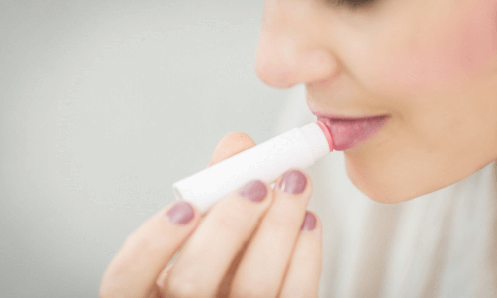 Woman putting chapstick on her lips