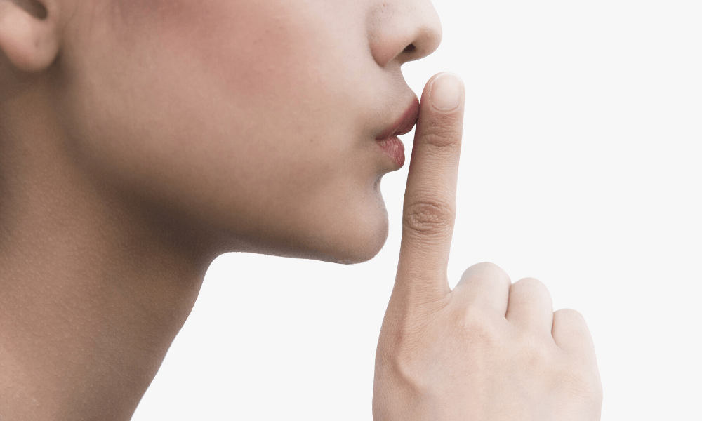 Woman with her finger to her lips for "shh"
