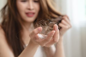 woman holding clump of hair